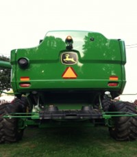 green tractor with a slow moving vehicle sign